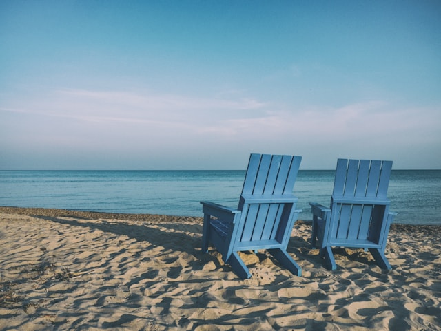 two blue beach chairs by the sea