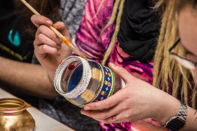 a woman decorating a jar