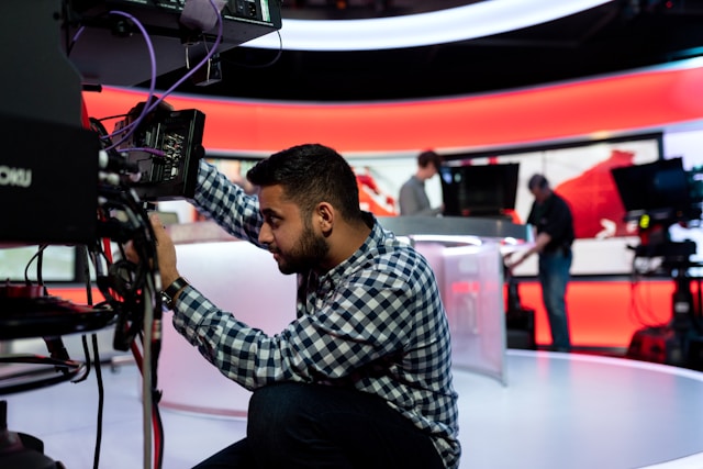 man operating television studio camera
